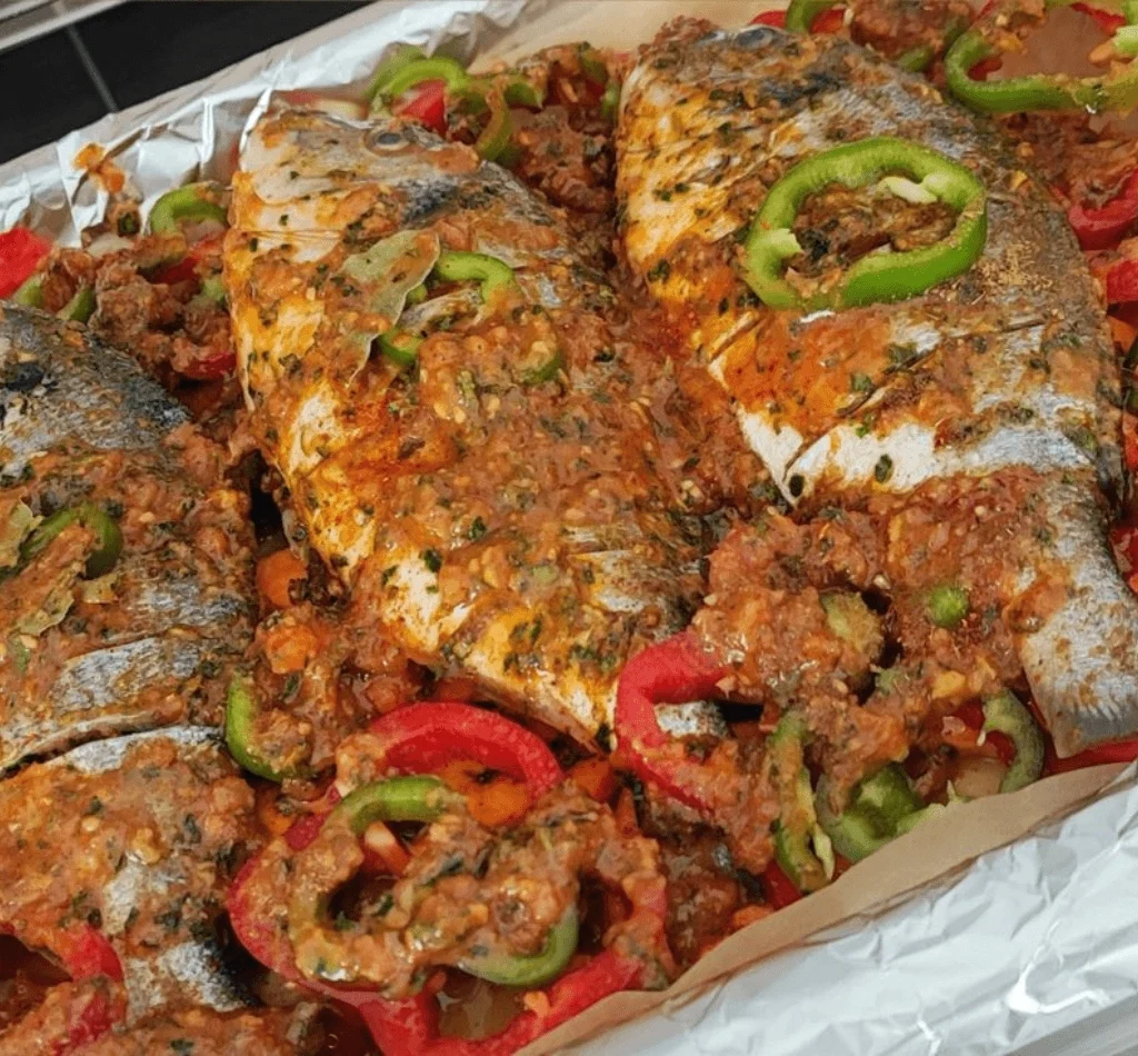 Traditional Egyptian food Sayadeya baked fish with peppers, onions, and spiced tomato sauce