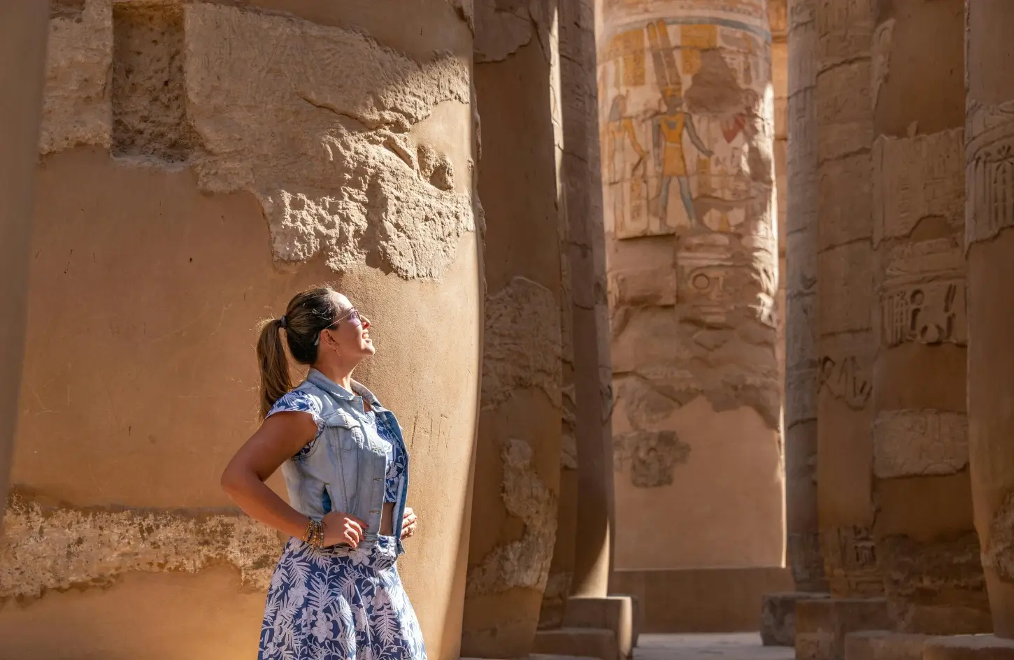 A female traveler looking up at the massive ancient columns and hieroglyphs of Karnak Temple in Luxor during a 14-day Egypt itinerary