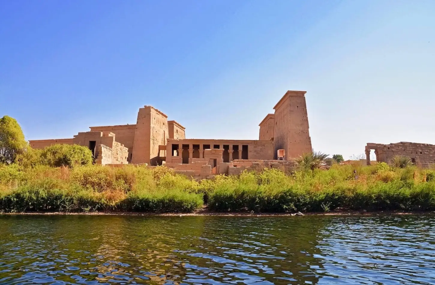Philae Temple complex ruins on Agilkia Island seen from a boat on the Nile River in Aswan.