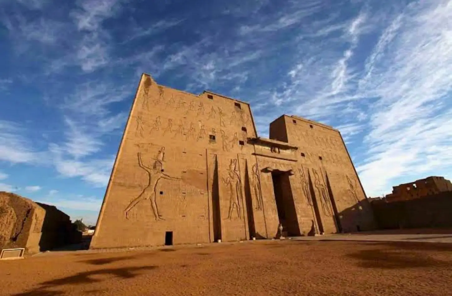 The towering entrance pylon of Edfu Temple decorated with ancient Egyptian wall reliefs.