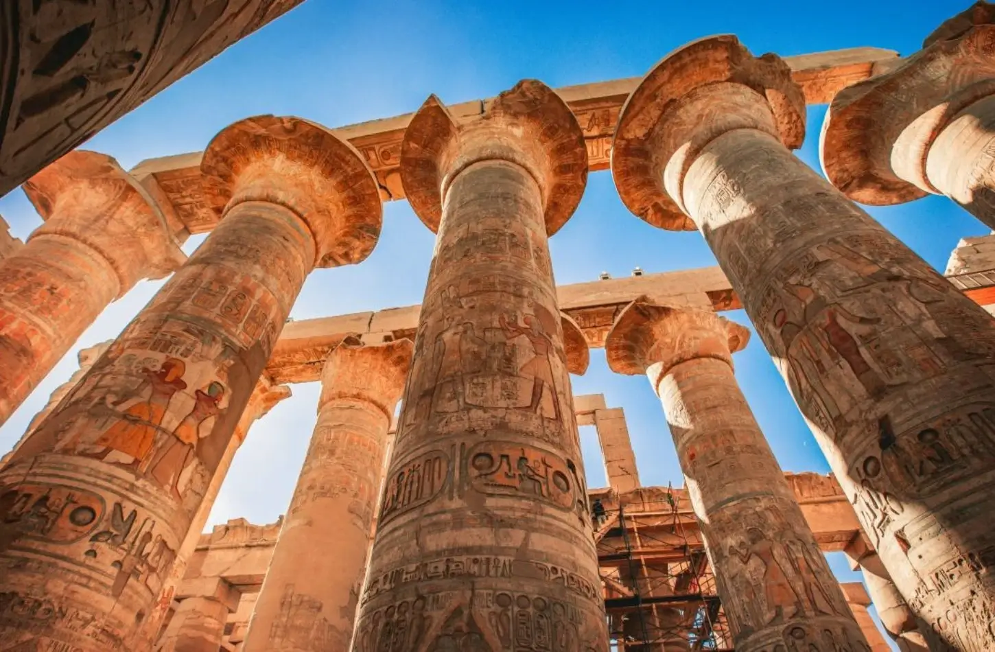 A low-angle shot of the towering, ancient stone columns with detailed hieroglyphics at Karnak Temple in Luxor, a highlight among the top things to do in Egypt.