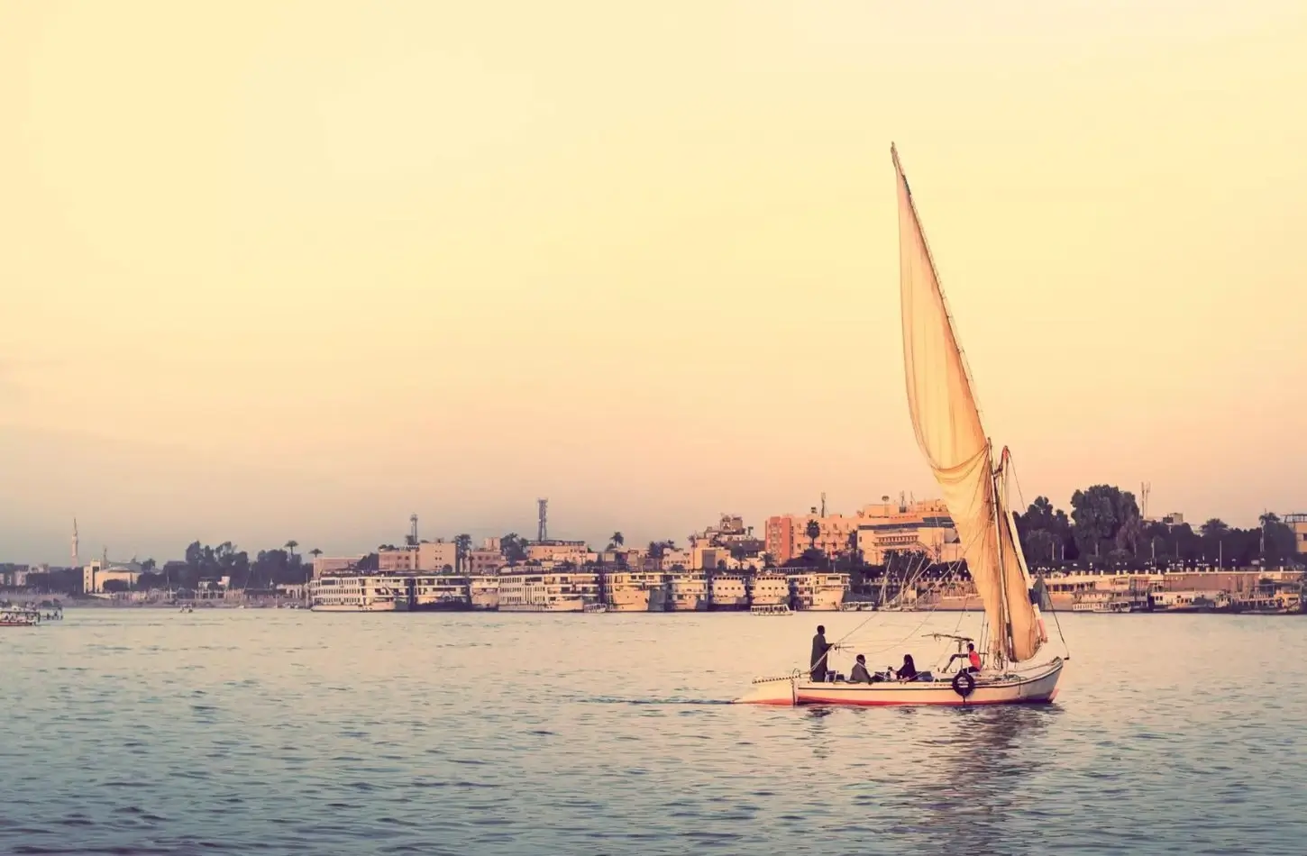 A traditional felucca sailboat on the Nile River in Luxor, demonstrating a scenic way for how to get around Egypt