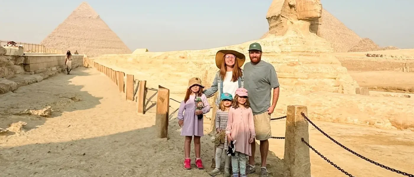 A-family-posing-for-a-photo-in-front-of-the-Great-Sphinx-and-pyramids-in-Giza