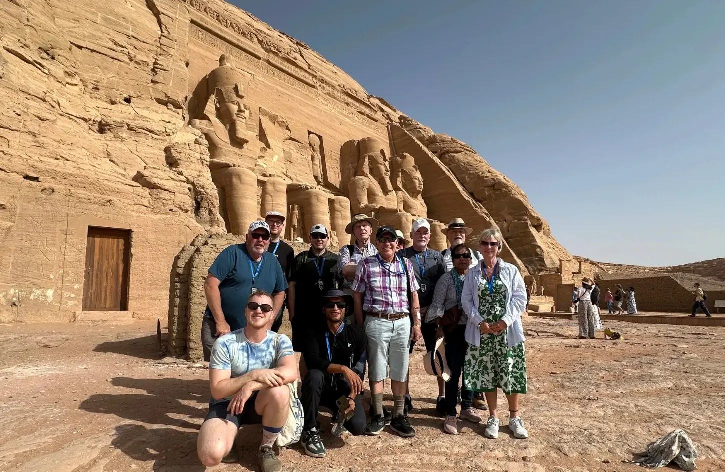 A travel tour group posing in front of the ancient statues of the Temple of Hathor and Nefertari at Abu Simbel during a trip to Egypt in September.