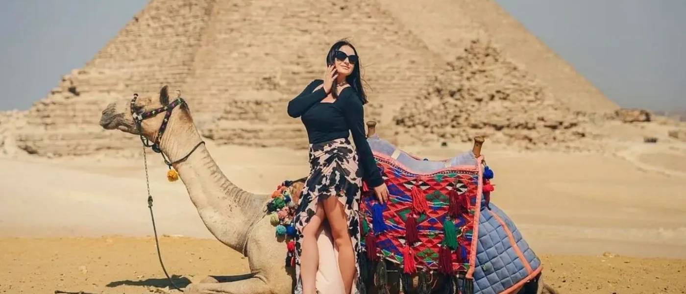 A woman posing next to a saddled camel in front of the Pyramids of Giza during a trip to Egypt in February.